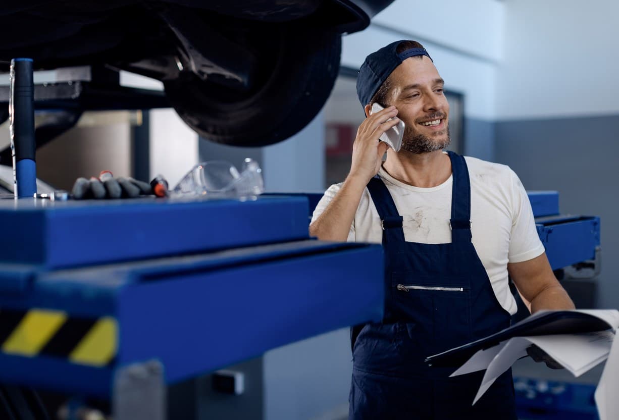 Service advisor taking a customer call in a busy workshop