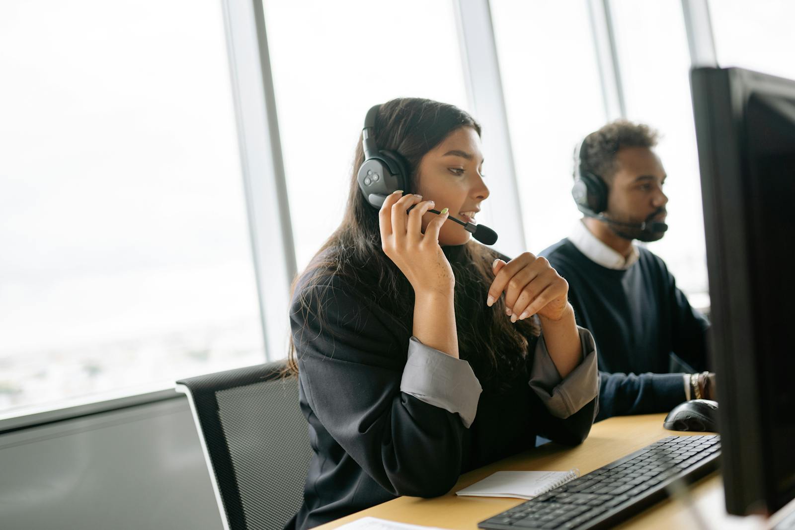 Contact center agents at workstations with headsets